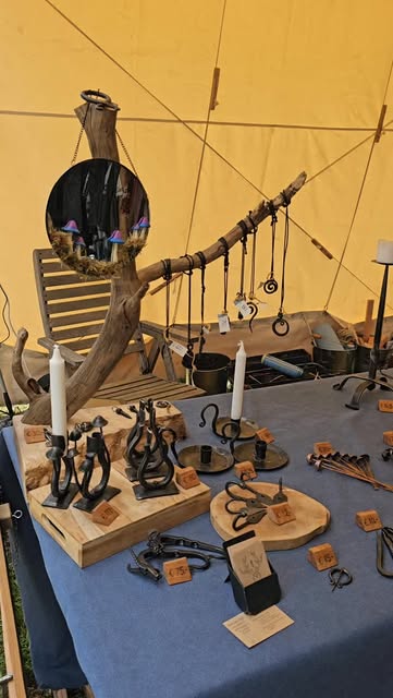 Overzicht van een marktkraam met handgesmede sieraden, kandelaars en andere kleine werken